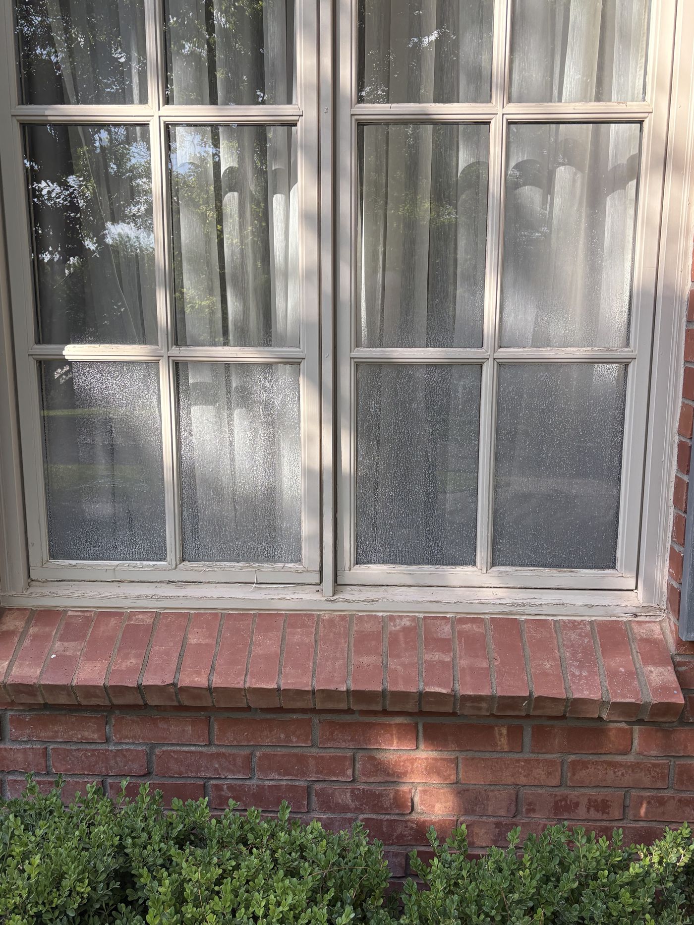 Paned window before cleaning, hazy with hard water spots
